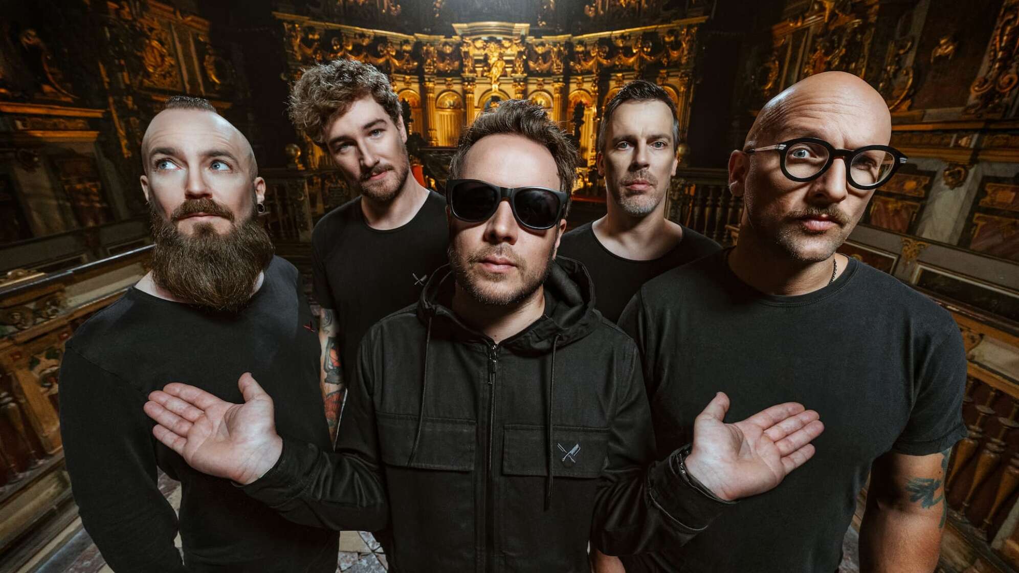 Die Bandmitglieder von Emil Bulls blicken in die Kamera, der Sänger trägt eine Sonnenbrille und hat die Arme ausgebreitet