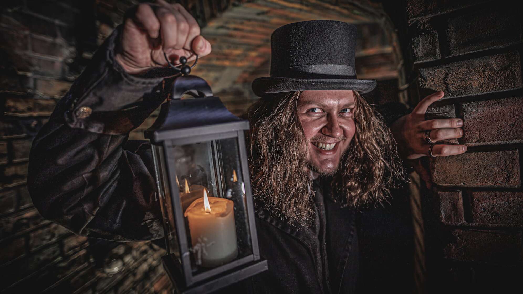 Foto aus dem Hamburg Dungeon mit einem Mann mit Laterne, der gruselig in die Kamera blickt