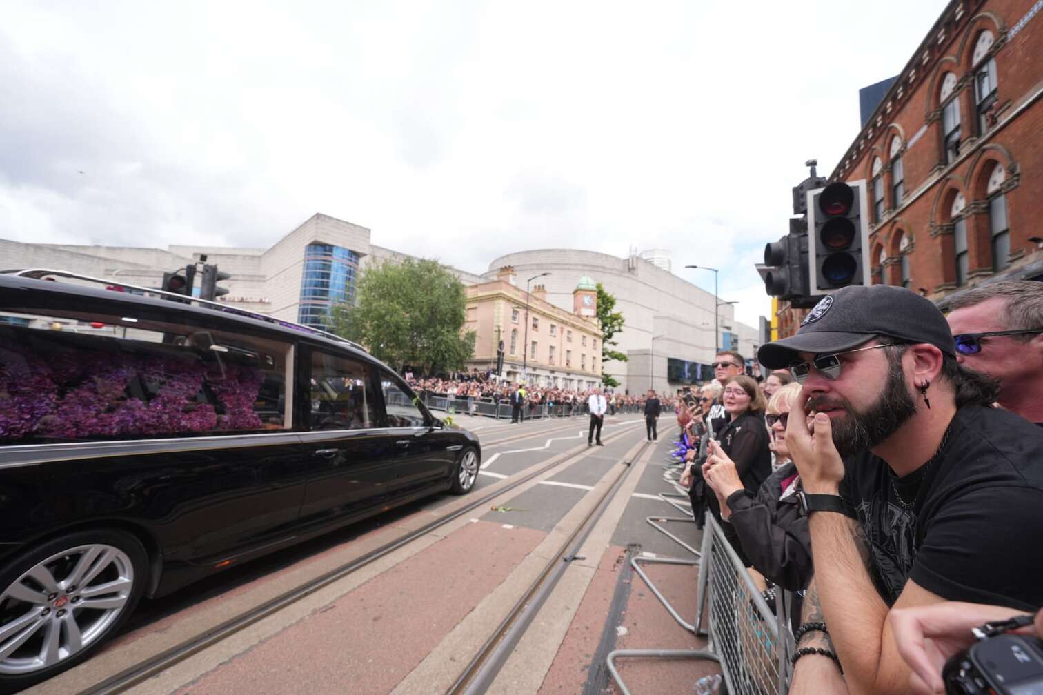 30.07.2025, Großbritannien, Birmingham: Der Leichenwagen mit dem Leichnam von Ozzy Osbourne ist in der Nähe der Black-Sabbath-Brücke in der Broad Street zu sehen, wo der Leichnam des Black-Sabbath-Frontmanns nach seinem Tod letzte Woche im Alter von 76 Jahren zu einer Prozession in seine Heimatstadt gebracht wird. Foto: Joe Giddens/PA Wire/dpa +++ dpa-Bildfunk +++