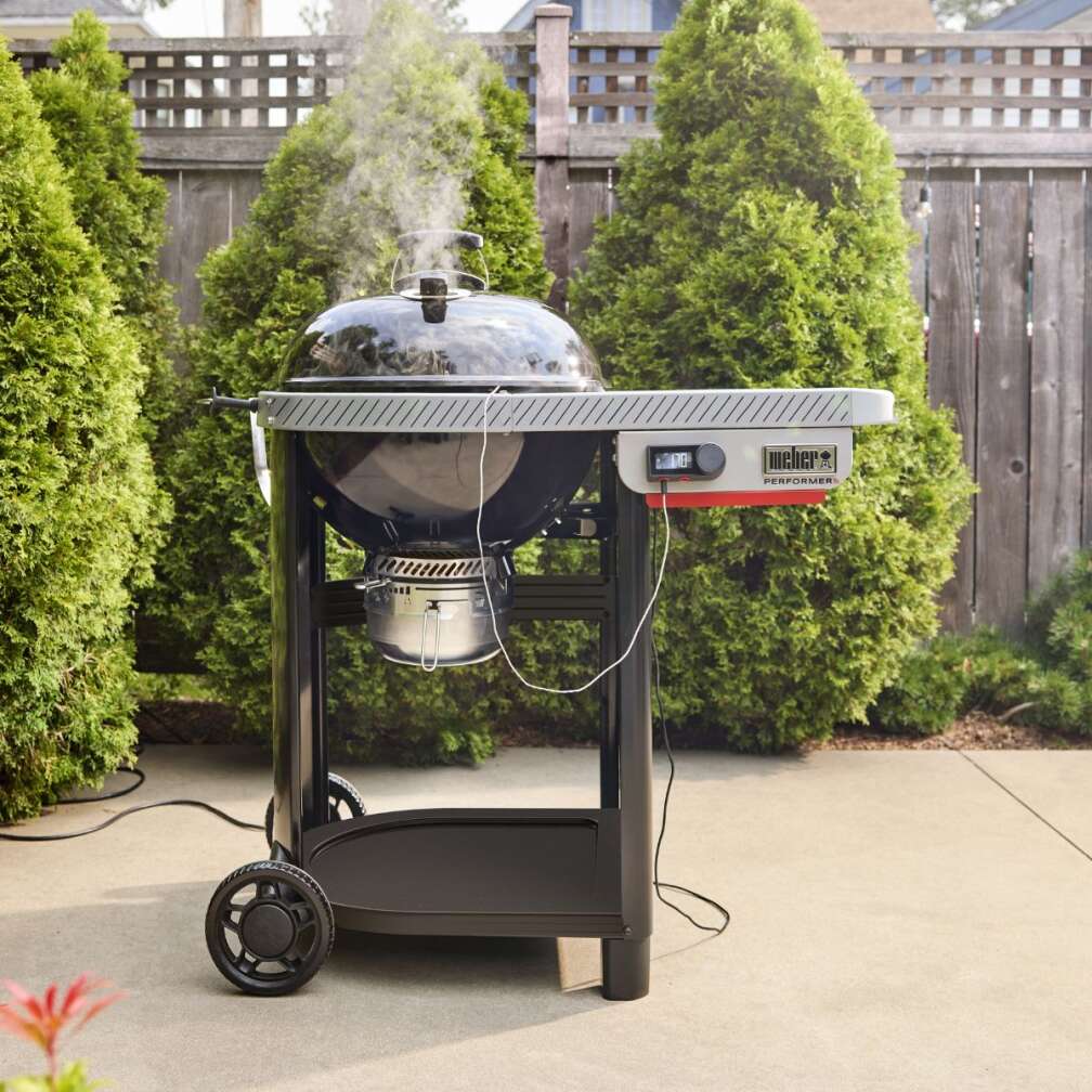 Der Performer Premium smarte Holzkohlegrill von Weber steht auf einer Terrasse