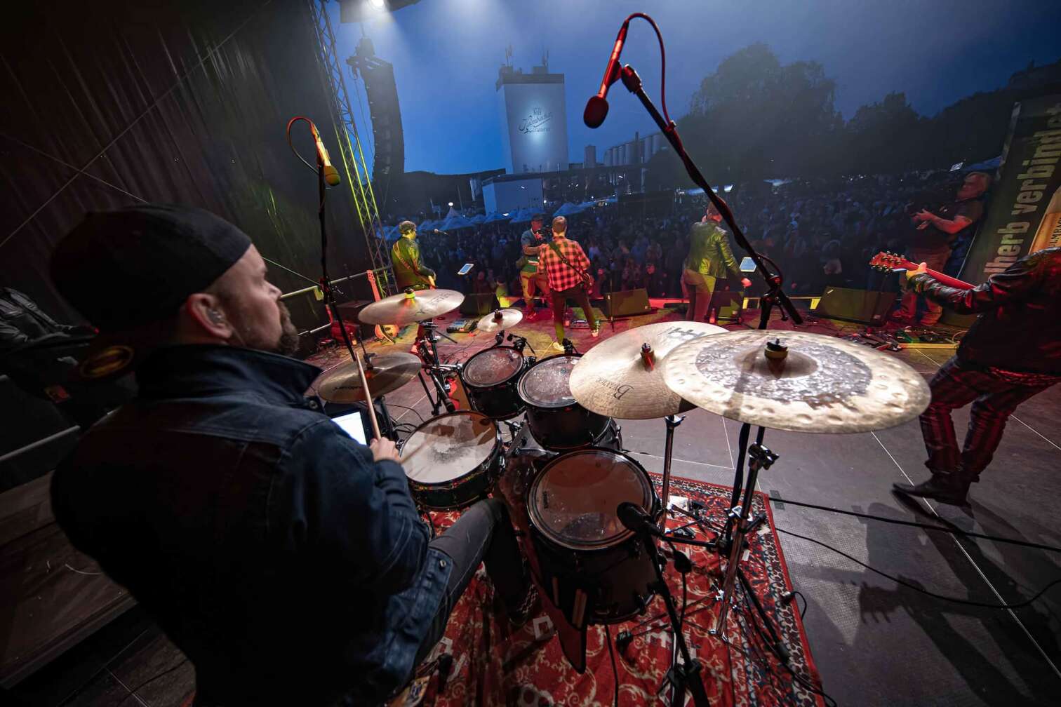 Die ROCK ANTENNE Band tritt bei der Motorradsternfahrt Kulmbach auf. Blick von der Schulter des Schlagzeugers auf das Publikum.